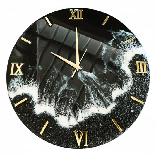Studio product shot of the Nandak Decors round black and white Resin art clock. The clock features clear black resin, white foamy waves, a textured black border, and prominent gold Roman numerals and hands, making it a perfect modern wall clock for living room.