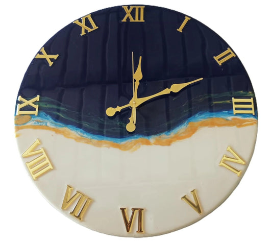 Close-up view of Nandak Decors handcrafted navy blue and beige resin art wall clock featuring golden Roman numerals and clock hands. The glossy resin surface captures an ocean wave effect, creating a modern and artistic wall decor piece suitable for living rooms, bedrooms, or office walls.